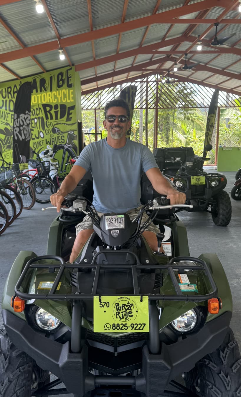 About us: Man riding ATV in rental shop.
